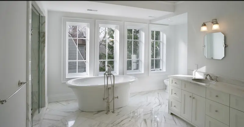 Renovated bathroom with freestanding tub, marble floor and white double vanity