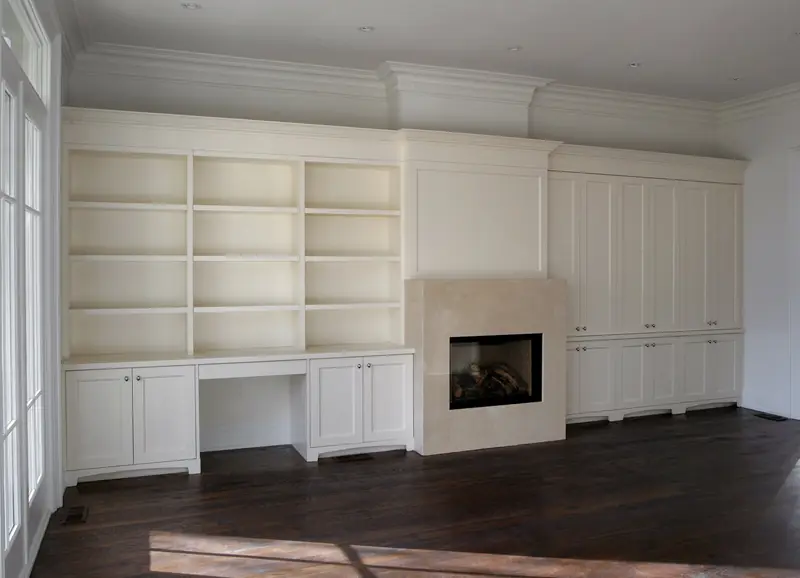 Floor-to-ceiling white built-in shelving framing a fireplace