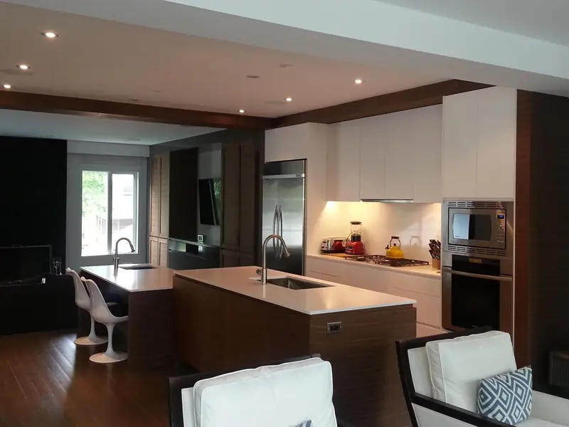 Kitchen with dark wood island, white cabinetry and bar stools