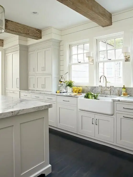 White shaker kitchen with farmhouse sink and exposed ceiling beam