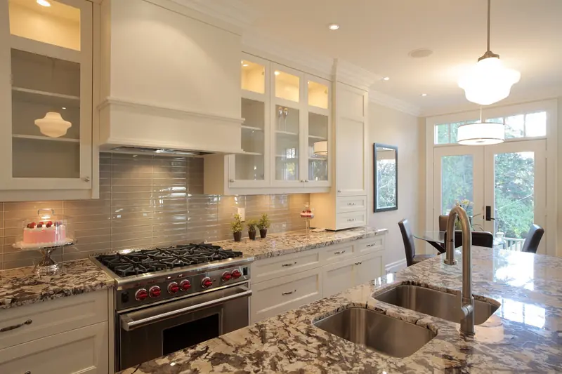 White kitchen with professional range and granite counters