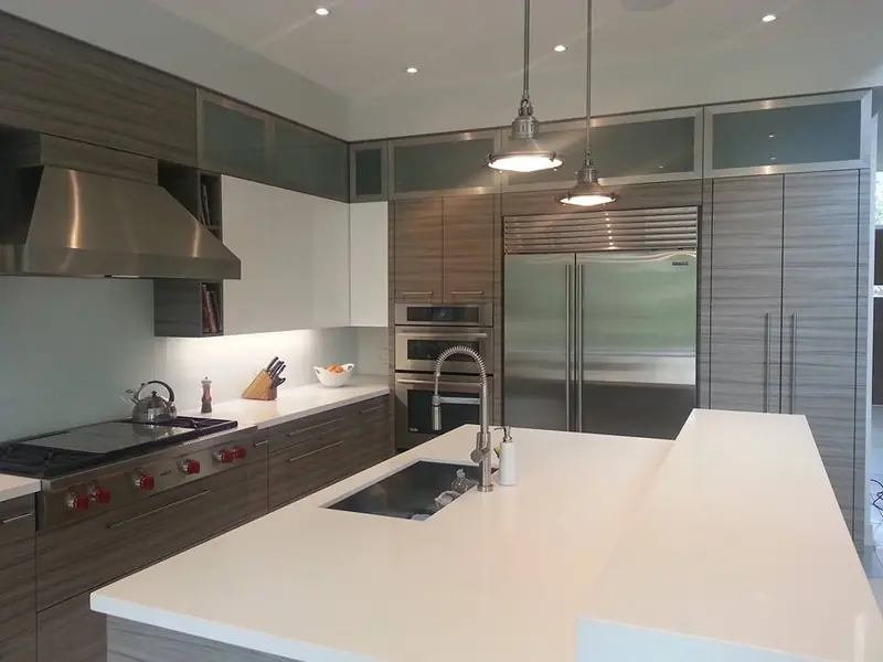 Modern kitchen with white island, stainless range and pendant lights
