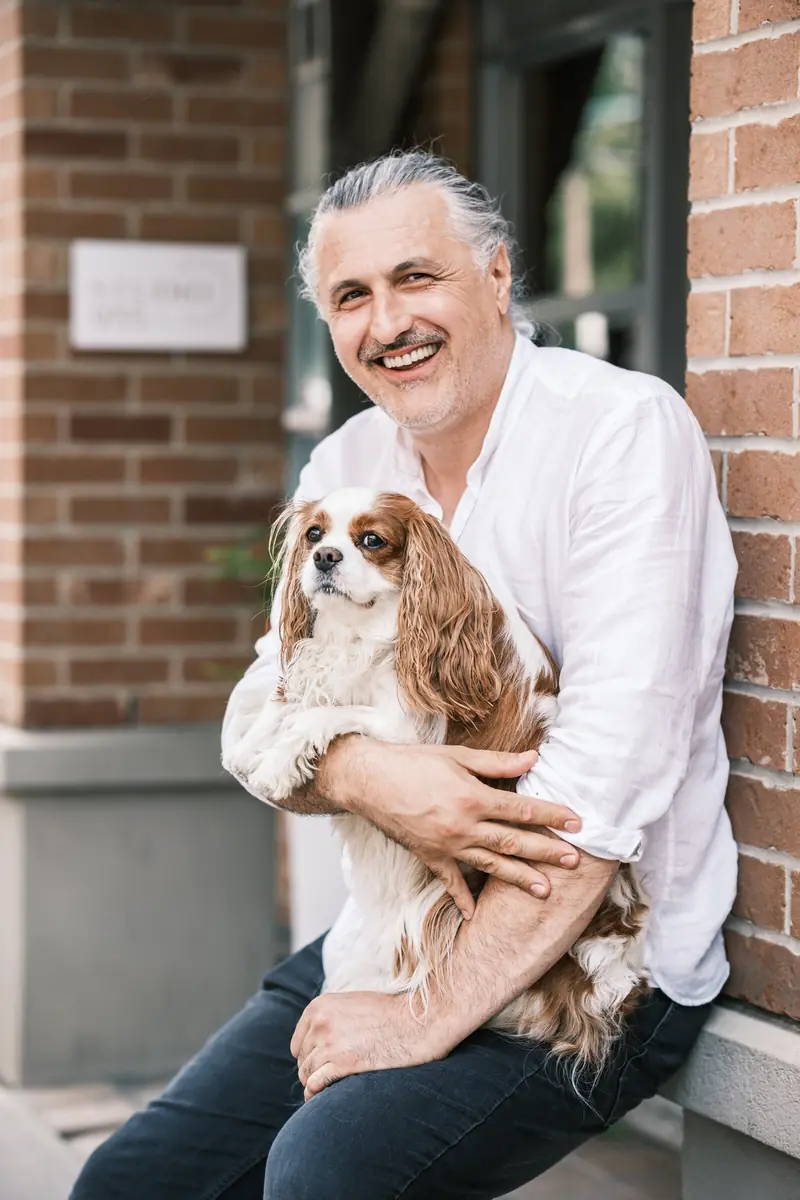 Sinisa Pajic, founder of Studio 955, holding his dog outside the studio