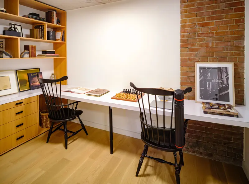 Oak shelving and desk wall against exposed brick in the Studio 955 design studio