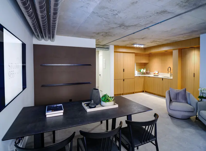 The Studio 955 meeting table and lounge, with oak millwork and a concrete ceiling